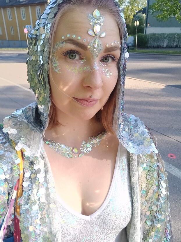 Selfie naisesta, kasvoilla timantteja ja glitteriä, pukeutuneena paljettikimonoon
